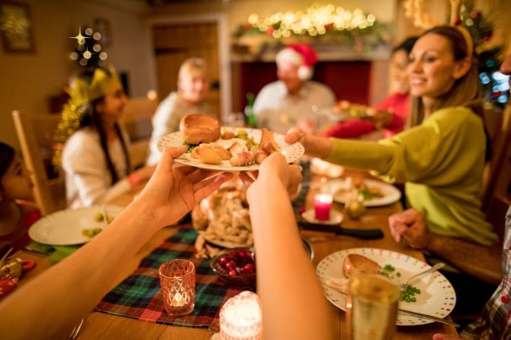 Persone felici intorno alla tavola con cenone natalizio